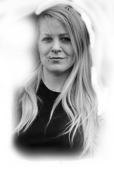 Tätowiererin Wien Kirsti - Porträt Porträt von Tätowiererin Kirsti mit langen blonden Haaren und Piercings in Nase und Lippe, Schwarz-Weiß-Foto, Ink21 Wien
