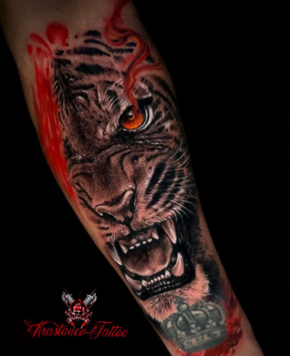 Realistisches Tiger-Tattoo am Unterarm, Black & Grey mit orangem Auge, Krone und roten Spritzern, von Veso, Wien
