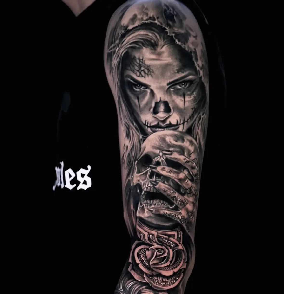 Arm Sleeve in Black & Grey: La Catrina mit Kapuze und Totenkopf-Schminke, eine Hand mit Totenkopf und eine Rose, Tattoo Wien