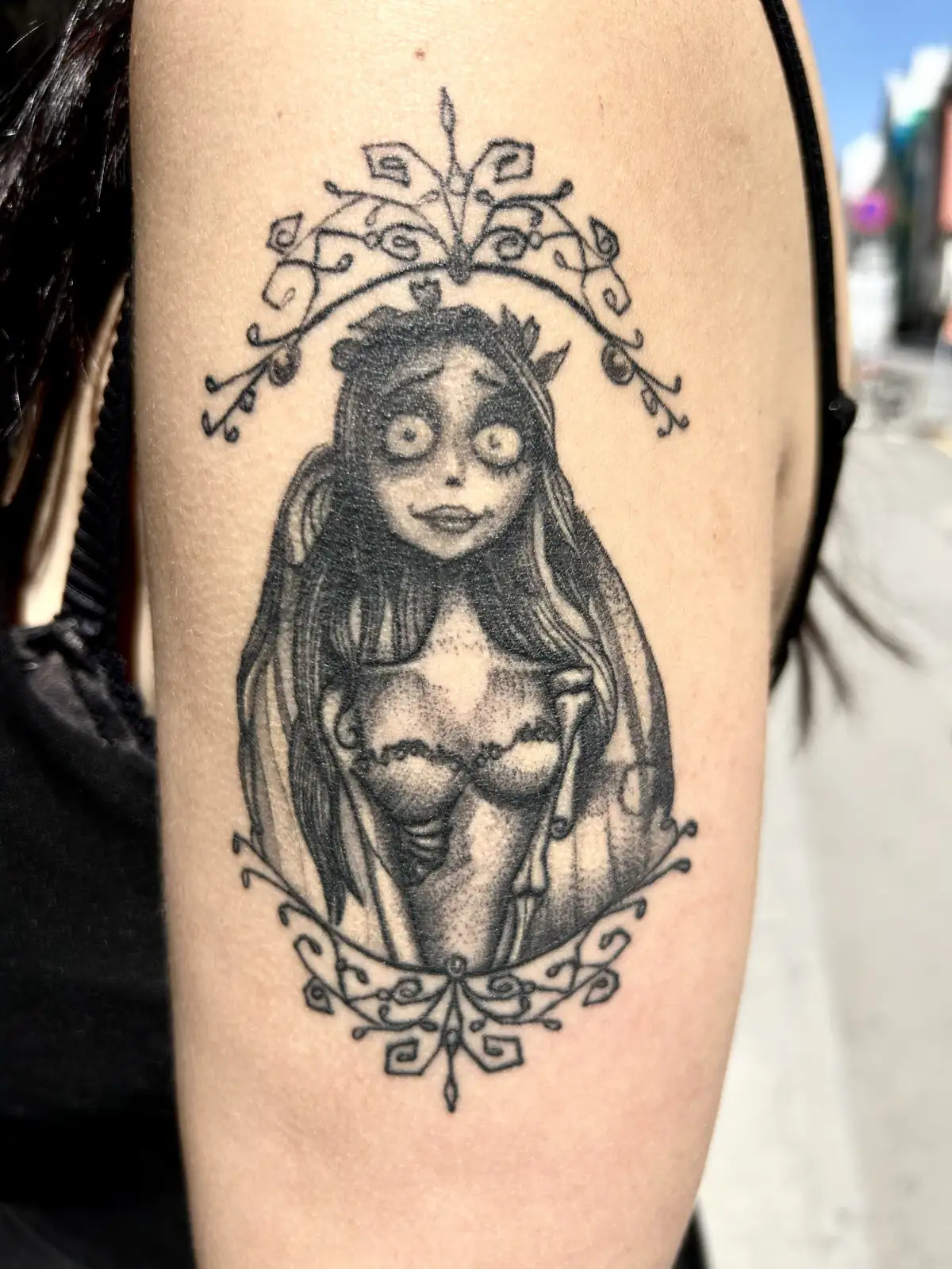 Dotwork Tattoo von Emily aus „Corpse Bride“ in einem verschnörkelten Ornamentrahmen am Oberarm, Black & Grey, Wien