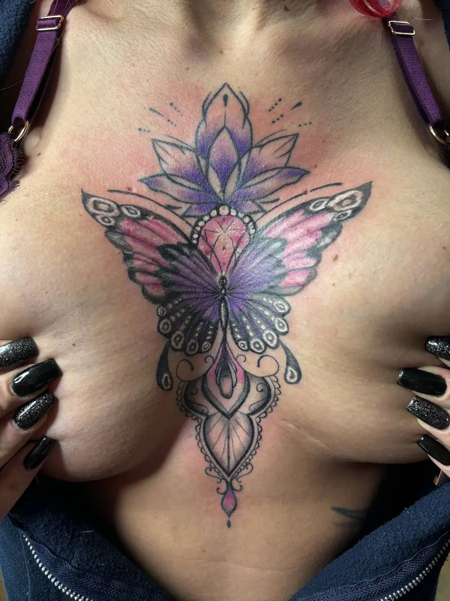 Farbiges Ornamental Sternum-Tattoo: Schmetterling in Lila und Rosa mit Lotusblüte und Mandala-Elementen, Tattoo Wien