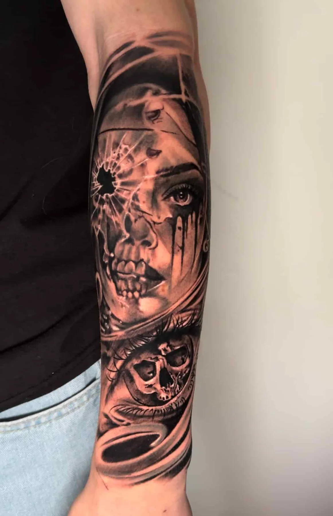 Realistisches Black & Grey Tattoo am Unterarm: Frauengesicht zerbricht am Einschussloch zum Totenkopf, Tattoo Wien